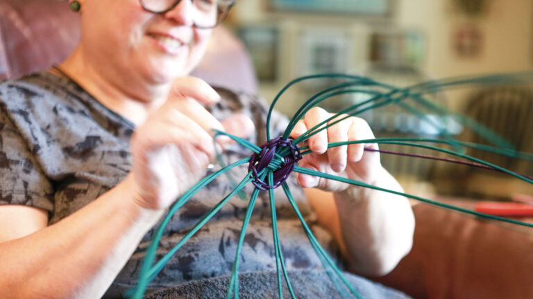 Regina “Reggie” Kastler weaves a green basket