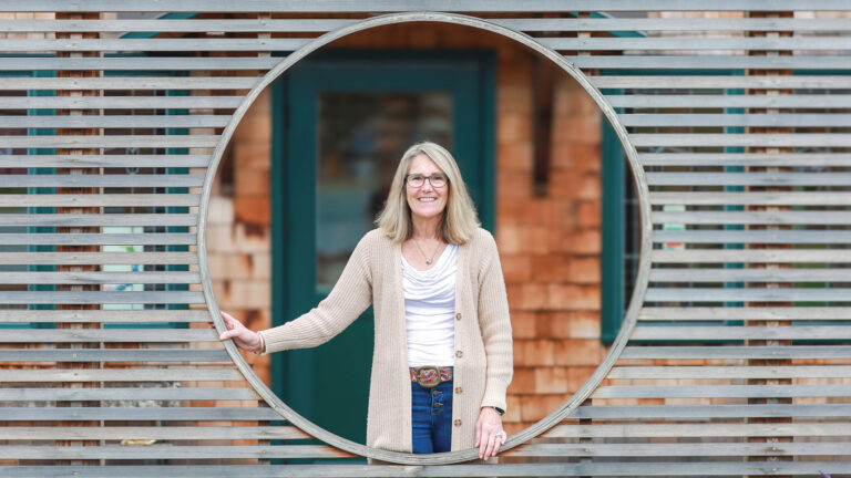 Elin Stebbins Waldal, director of Healing Circles Langley stands in the center of the decorative fence outside the building
