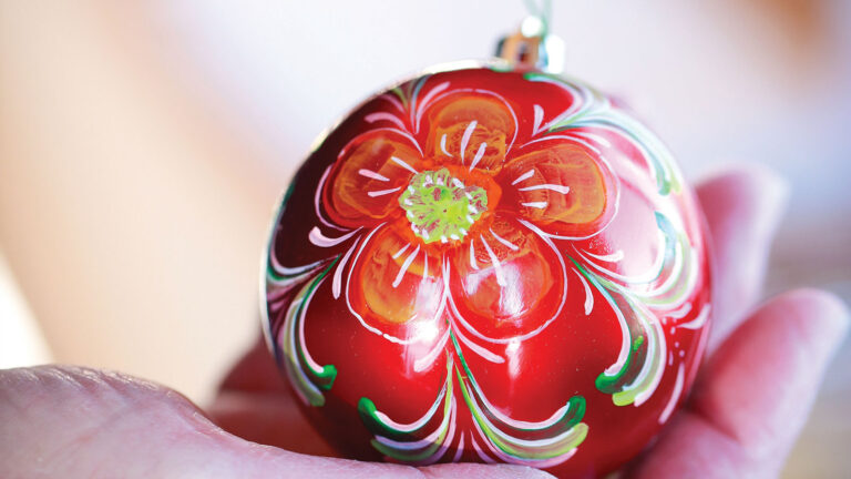 closeup of red Christmas ornament painted in rosemaling style