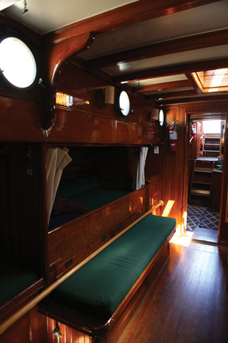 Interior cabin with wood bunks of Schooner Suva