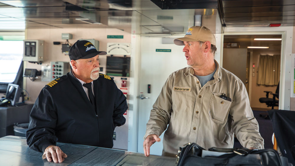Captain talks with crew member in ferry's bridge