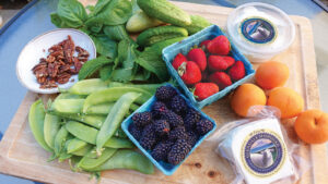 Strawberries, blackberries and assorted greens on a table